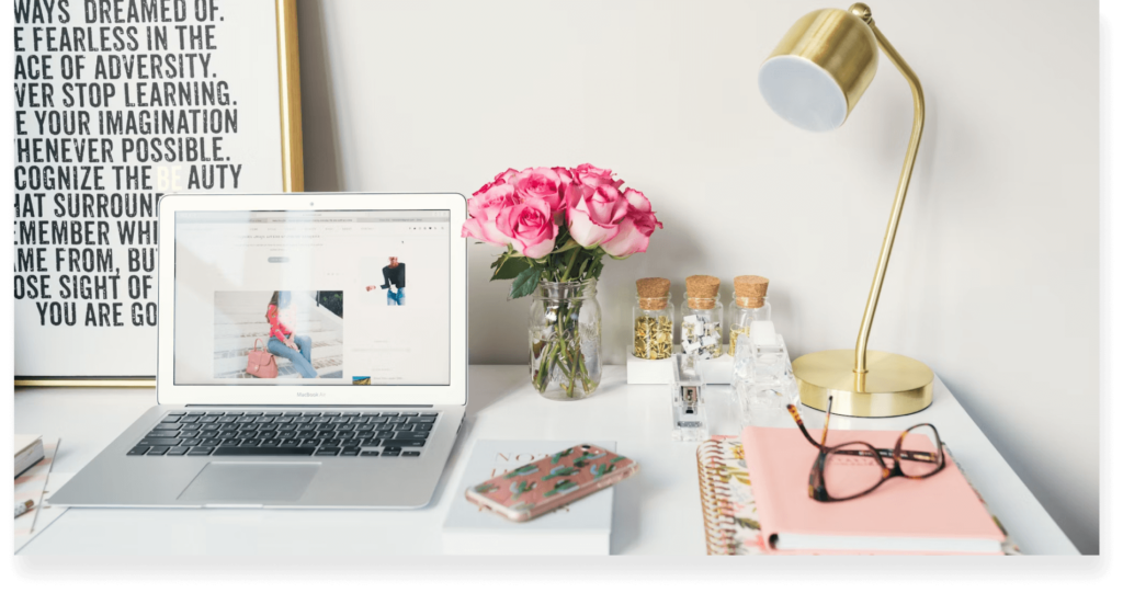 A typical editor's desk setup with a laptop, notebooks, phone, and other paraphernalia.