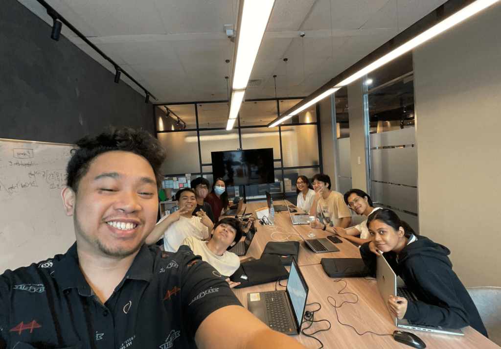 A diverse group of designers, developers, and marketers posing for a photo in a conference room.