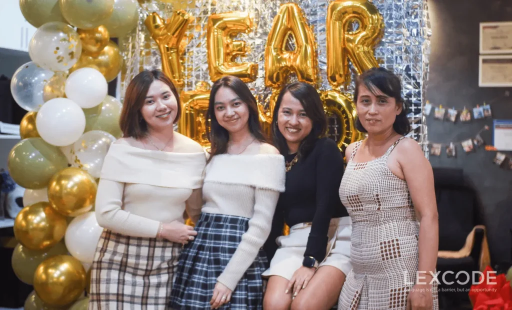 Lexcode Inc.'s operations team poses in front of gold balloons and festive decorations at the office during the 2024 year-end party.