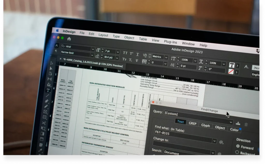 Laptop screen showing Adobe InDesign 2023 in use, editing a document layout.