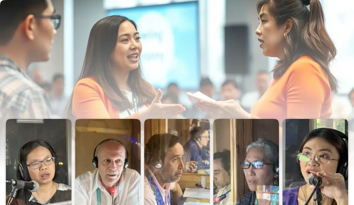 Professional business meeting with two women discussing while simultaneous interpreters work in booths below Caption: International business conference featuring live simultaneous interpretation services